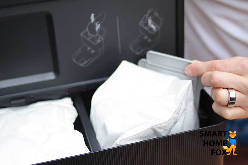A dust bag is changed in the iRobot Roomba emptying station.
